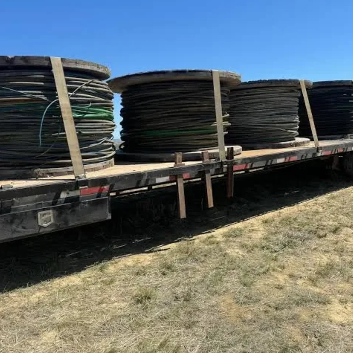Loaded flatbed of cable reels and wooden pallets