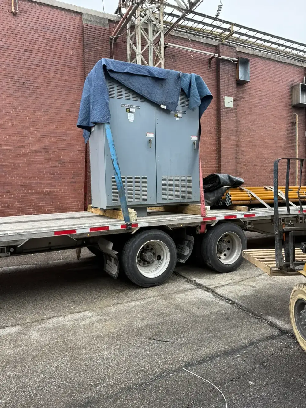 Pad-mount transformer strapped to a Southern Breakers flatbed for pickup